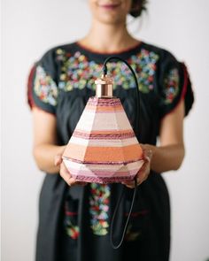 a woman holding a lamp in her hands