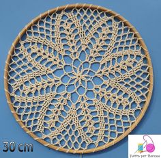 a circular doily made with crochet on a blue background