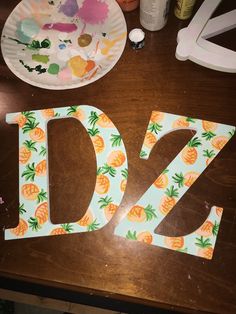 the letter d is made up of pineapples and painted with acrylic