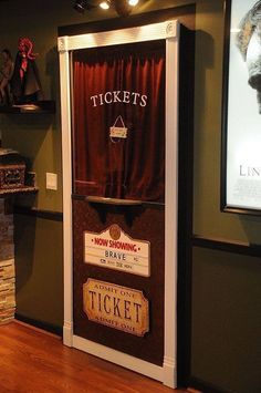 a ticket machine sitting on top of a hard wood floor next to a red curtain