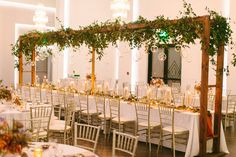 the tables are set with white linens and greenery for an elegant wedding reception