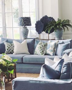 a living room filled with blue couches and vases on top of each other