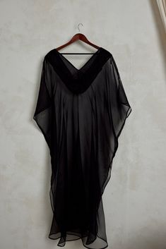 The Diana Kaftan serves sheer luxury romance and is made from 100% silk organza. Crisp and smooth with a matte finish, this black sheer kaftan can be layered over your favorite swimsuit or bodysuit. Diana is intentionally minimal to allow you to style and accessorize to your hearts desire. Elevate your lounging, evening events and resortwear with its breezy high side slits and ultimate versatility. You can style Diana with wide legged trousers or jeans for a more fun look. We recommend dressing Chic Silk Kaftan For Beach Cover-up, Elegant Silk Chiffon Beach Dress, Flowy Party Beachwear Cover-up, Black Silk Chiffon Summer Dresses, Black Silk Chiffon Dresses For Summer, Flowy Beachwear Kaftan For Party, Flowy Black Beachwear Cover-up, Sheer Silk Beach Dress, Sheer Flowy Cover-up