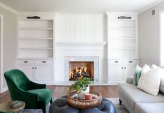 a living room filled with furniture and a fire place in the middle of the room