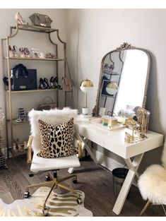 a white desk with a leopard print pillow on it and a gold framed mirror in the corner