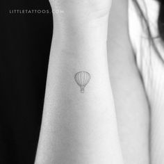 a small hot air balloon tattoo on the wrist