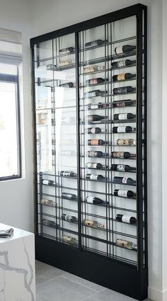 a large display case filled with lots of bottles in a room next to a window