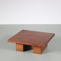 a small wooden table sitting on top of a gray floor