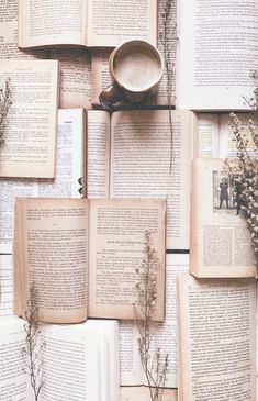 an arrangement of books and flowers on a wall