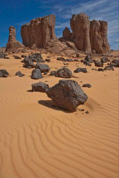 rocks and sand in the desert under a blue sky