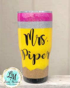 a yellow and pink cup with the words mrs piper painted on it's side