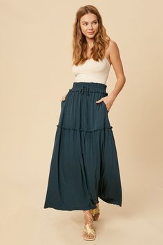 So flowy and femme! The Adele Maxi Skirt is featured in a high-rise, tiered silhouette that we know you'll love! -Color: Emerald -Stretched rayon jersey fabric -Tiered maxi skirt with ruffle detail -Drawstring waist -Side seam pockets -Lined -Length: 39" -Content: 95% Rayon 5% Polyester -Imported -Model is 5' 9" 34-24-35 and wearing a size Small Maxi Skirt Spring, Mom Uniform, Western Skirts, Blue Maxi Skirt, Tiered Maxi Skirt, Summer Capsule Wardrobe, Tier Skirt, Knit Skirt, Adele