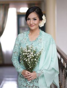 a woman in a blue dress holding a bouquet of flowers