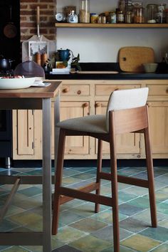 a kitchen with wooden cabinets and counter tops, two stools in front of the counter