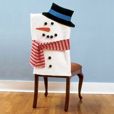 a snowman sitting on top of a wooden chair