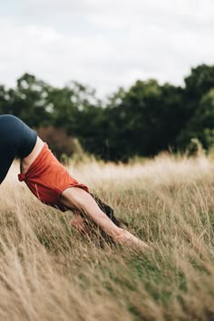 a woman is doing yoga in the grass