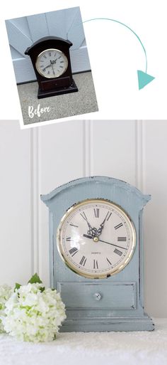 an old blue clock sitting on top of a table next to a vase with flowers