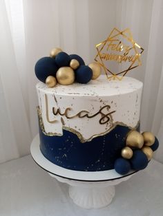 a white and blue cake with gold decorations