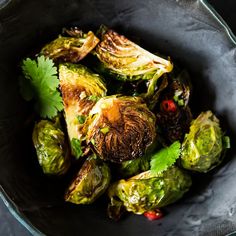 a bowl filled with brussel sprouts and garnished with cilantro