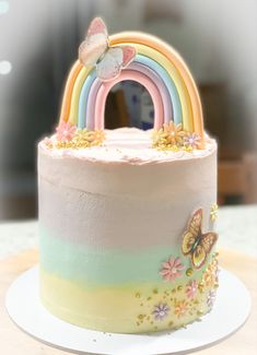 there is a cake that has a rainbow decoration on the top and bottom tiers