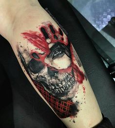 a person with a tattoo on their arm that is covered in red ink and has a skull