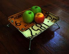 two apples are sitting on top of a plate with the number six in front of them