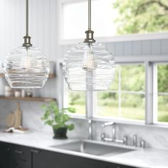 two glass globe lights hanging over a kitchen sink