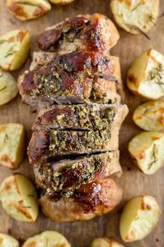 sliced pork with herbs and potatoes on a cutting board