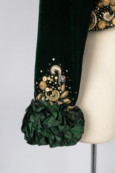 NINA RICCI  -  (Made in France) Set composed of a dress and a bolero. The green silk satin bustier dress is embroidered with sequins and silvery and golden thread on the bustier. The lining of the skirt part is in tulle. The green velvet bolero is embroidered with patterns matching with the dress, and sewn with green taffeta flounces on the sleeves. No size nor composition label, it fits a 36FR. 1991-1992 Fall-Winter Haute Couture Collection. To be mentioned, rare threads are pulled out on the s Nina Ricci Dress, Velvet Bolero, Saint Laurent Clothes, Satin Bustier, Golden Thread, Timeless Brand, Brooch Necklace, Pattern Matching, Bustier Dress