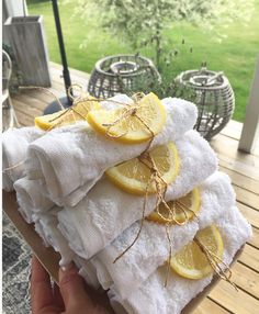 a person holding a stack of towels with lemons on them