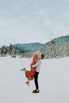 a man and woman hugging in the snow