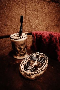 two cups with toothbrushes in them sitting on a table next to a towel