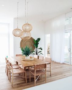 a dining room table with chairs and plants