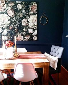 a dining room table with chairs and a painting on the wall