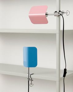 two different colored lamps sitting on top of shelves