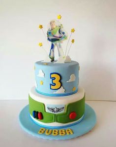 a three tiered birthday cake with toy story characters on the top and number 3 on the bottom