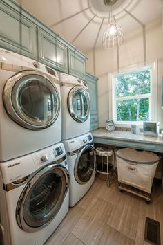 a washer and dryer are stacked in the corner of this laundry room with an island