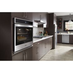 a modern kitchen with stainless steel appliances and dark wood cabinets