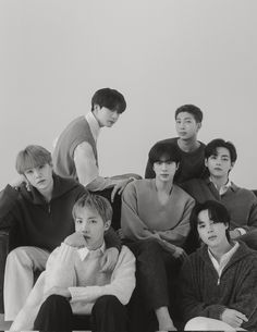 black and white photo of group of young men sitting on couch with one man looking at the camera