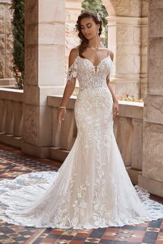 a woman in a white wedding dress standing on a tiled floor next to an archway