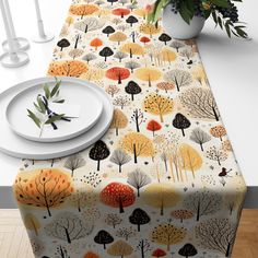 the table cloth is decorated with trees and leaves