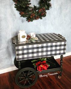 a black and white checkered table with christmas decorations on it, next to a wreath