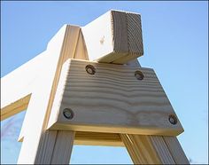 an unfinished wooden chair against a blue sky