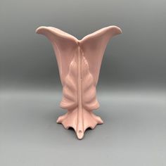 a pink vase sitting on top of a table