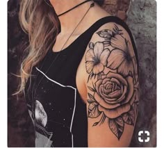 a woman with a black and white rose tattoo on her arm