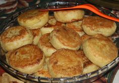 a glass bowl filled with small pastries on top of a table next to an orange handled utensil