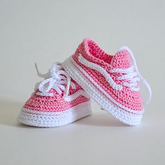 crocheted pink and white tennis shoes with laces on the soles are shown