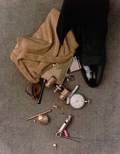 a pair of black shoes sitting on top of a floor next to other items and accessories