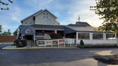 a large white building with a clock on it's front porch and fenced in area