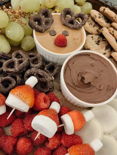 an assortment of desserts on a platter with fruit, pretzels and chocolate